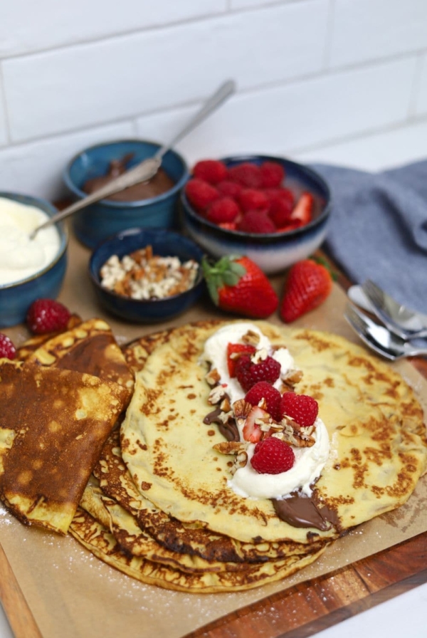 A display of sourdough discard crepes topped with nutella, whipped cream and berries.