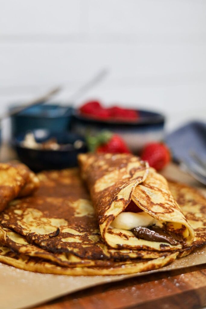 A sourdough crepe filled with nutella and cream and rolled up. 