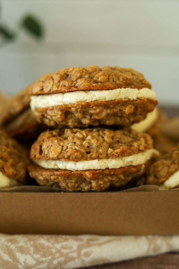 A close up of 2 sourdough oatmeal cream pies filled with vanilla cream filling.