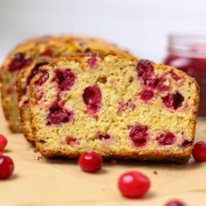 A close up photo of a slice of sourdough cranberry banana bread.