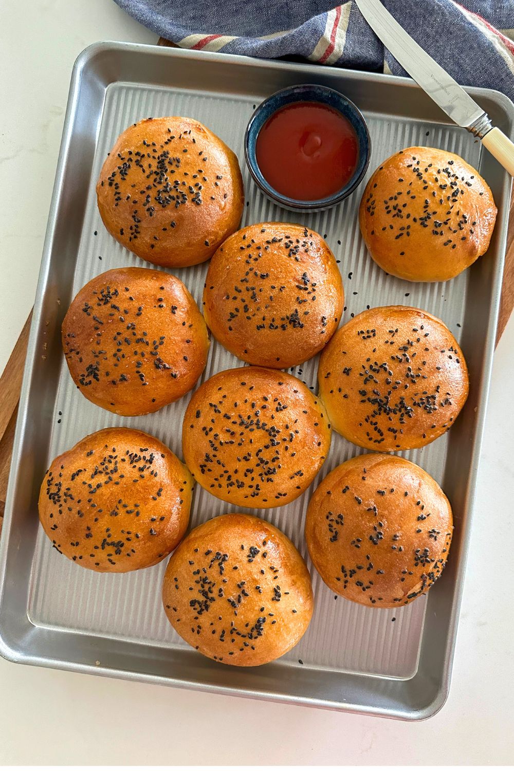 Sourdough buns on a baking sheet.