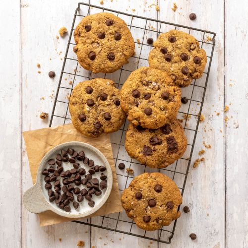 Sourdough chocolate chip cookies cooling on a wire rack.