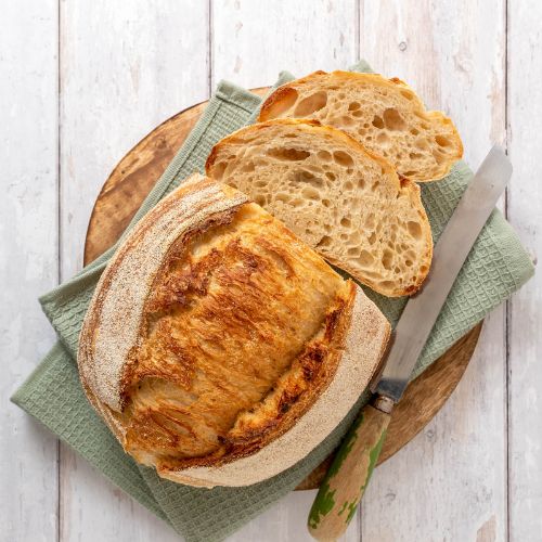 Loaf of sourdough on a wooden background.