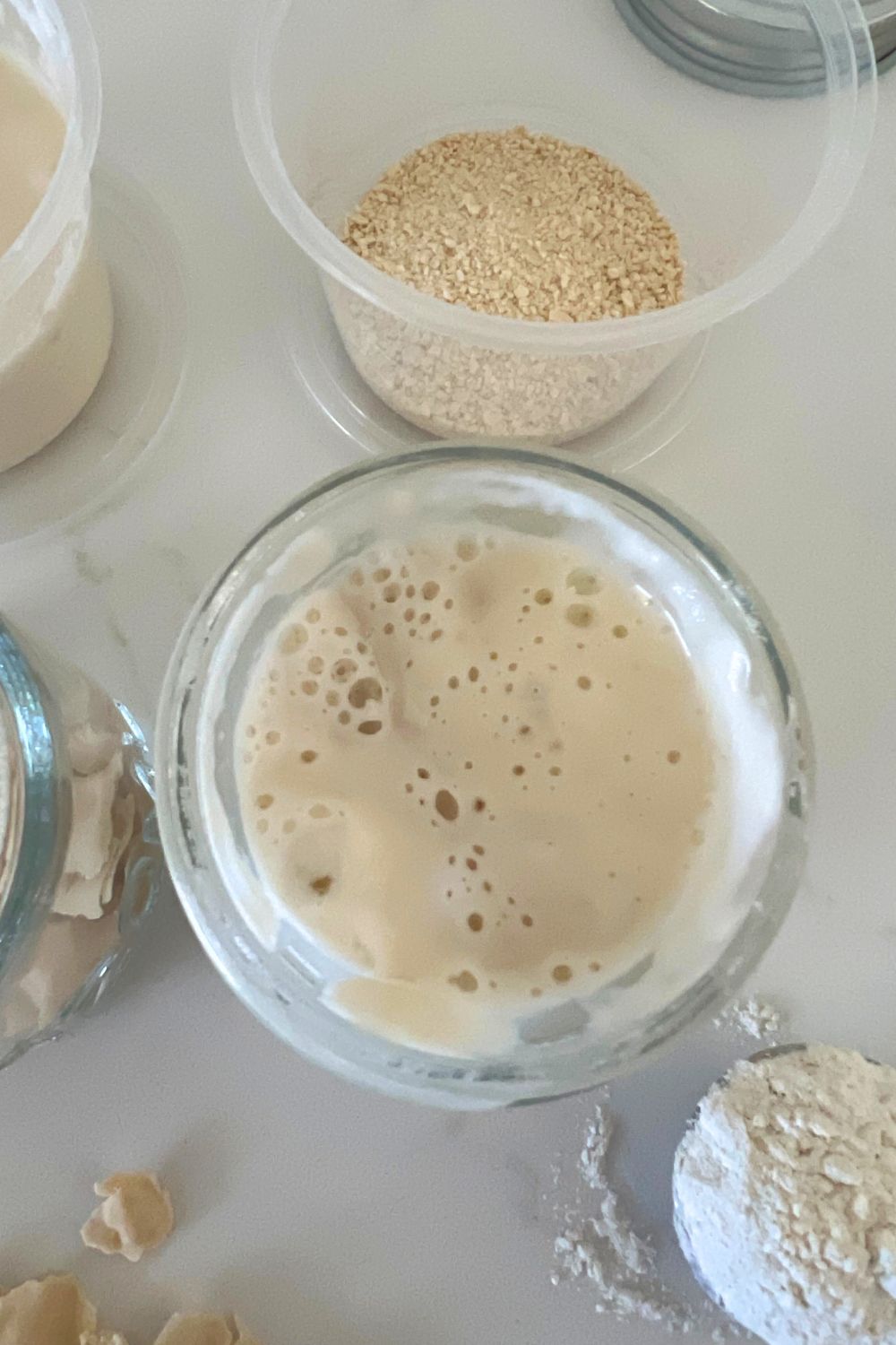 Overhead of sourdough starter in a small glass jar.