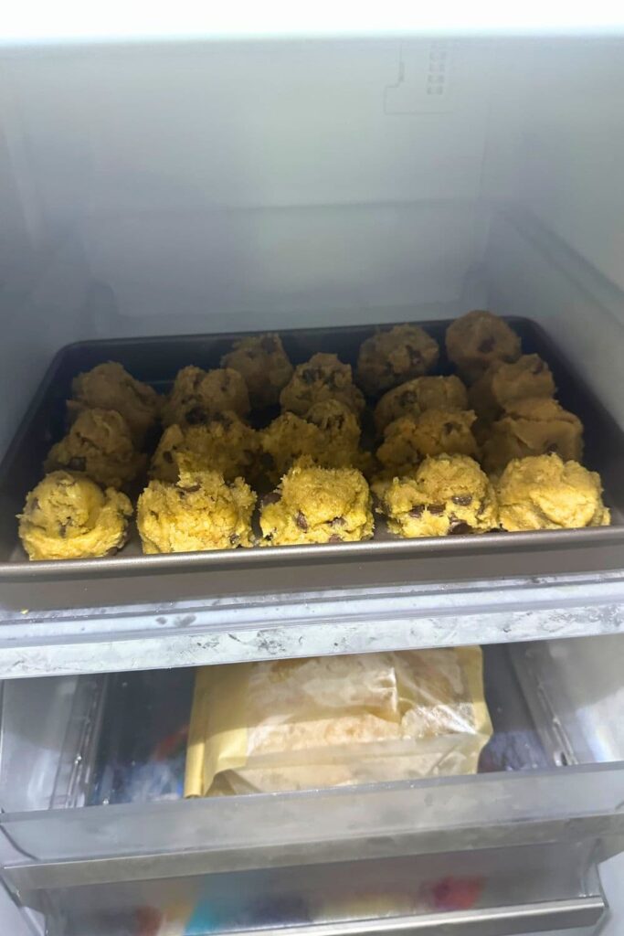 A tray of sourdough chocolate chip cookie dough that has been scooped out and placed in the freezer to snap freeze.