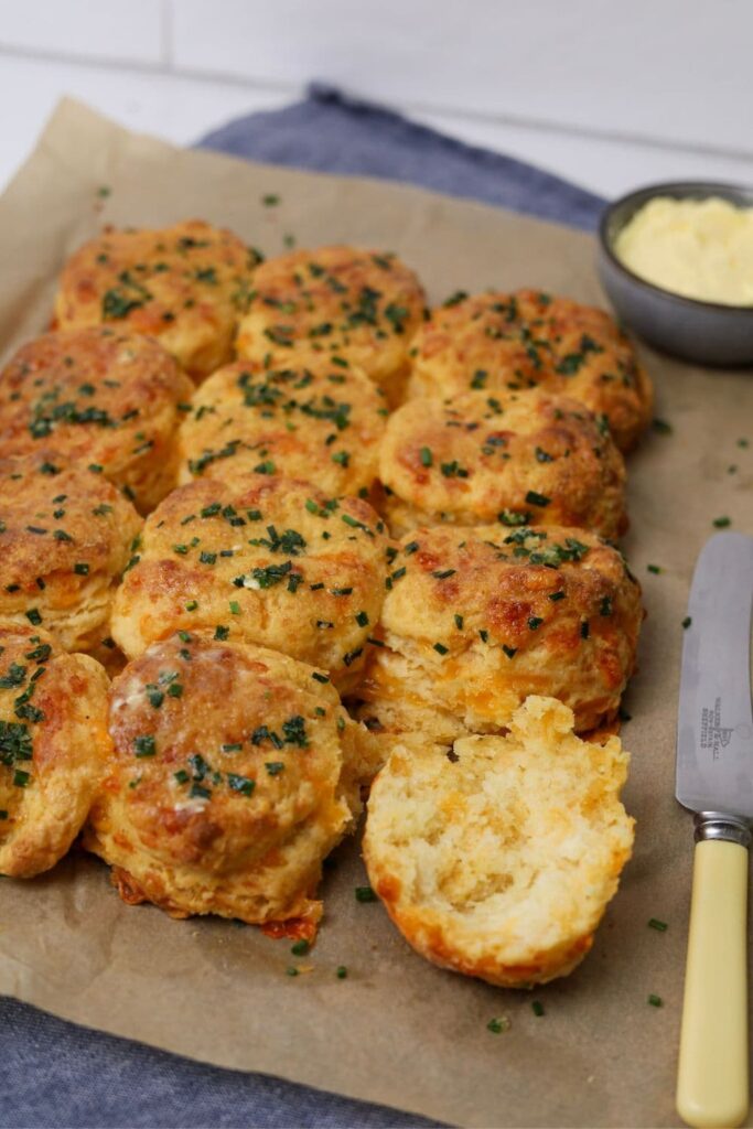 A tray of sourdough cheddar biscuits straight out of the oven brushed with garlic herb butter.