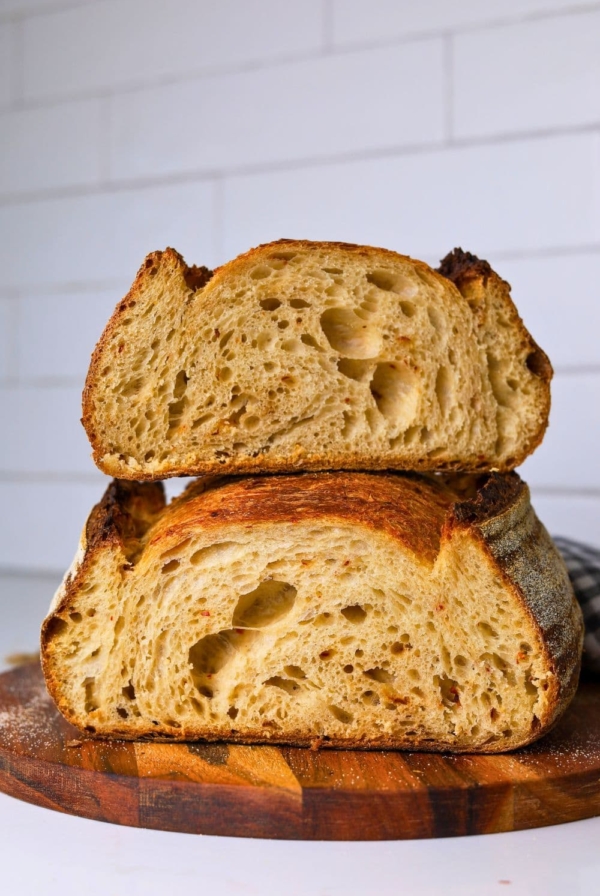 Two halves of a hot honey sourdough loaf stacked on top of each other so you can see the crumb inside.