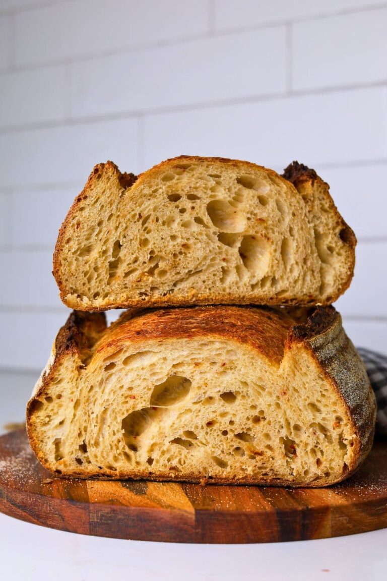 Two halves of a hot honey sourdough loaf stacked on top of each other so you can see the crumb inside.