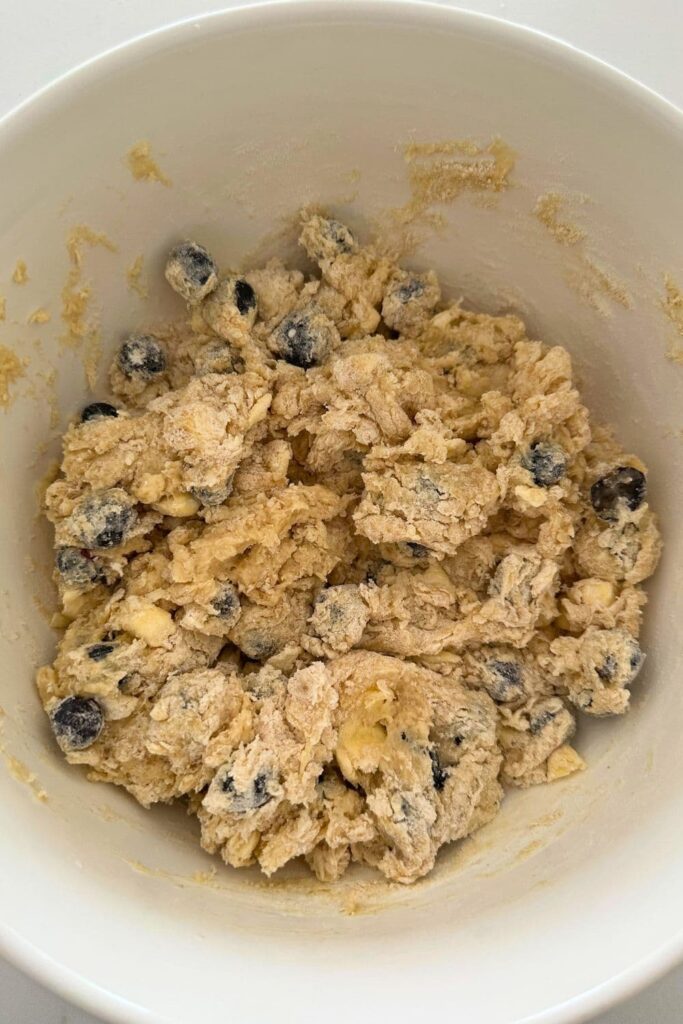 A bowl of shaggy dough ready to make sourdough blueberry scones.