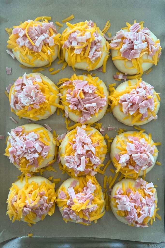 A tray of sourdough bacon and cheese rolls ready to be baked in the oven.