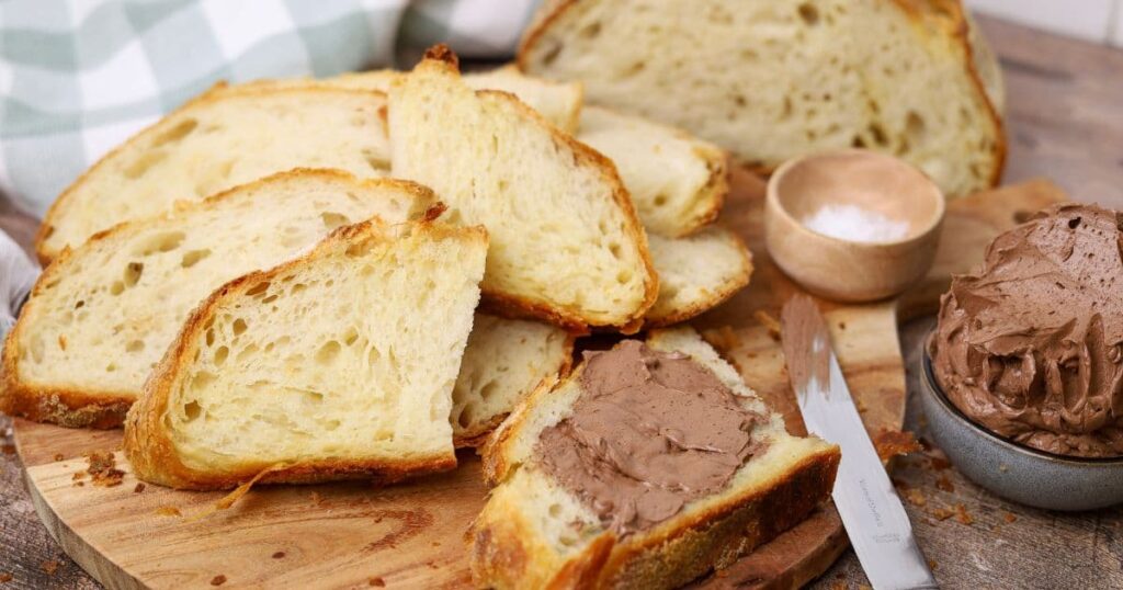 A loaf of sourdough croissant loaf sliced and served with whipped chocolate butter.