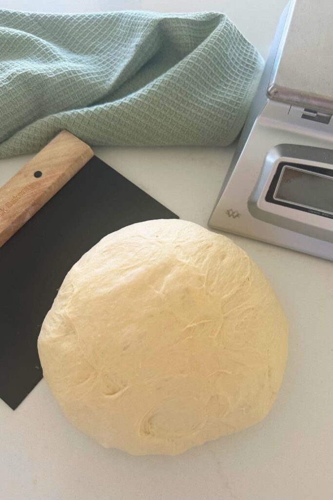 A round of dough ready to be shaped into sourdough pita bread.