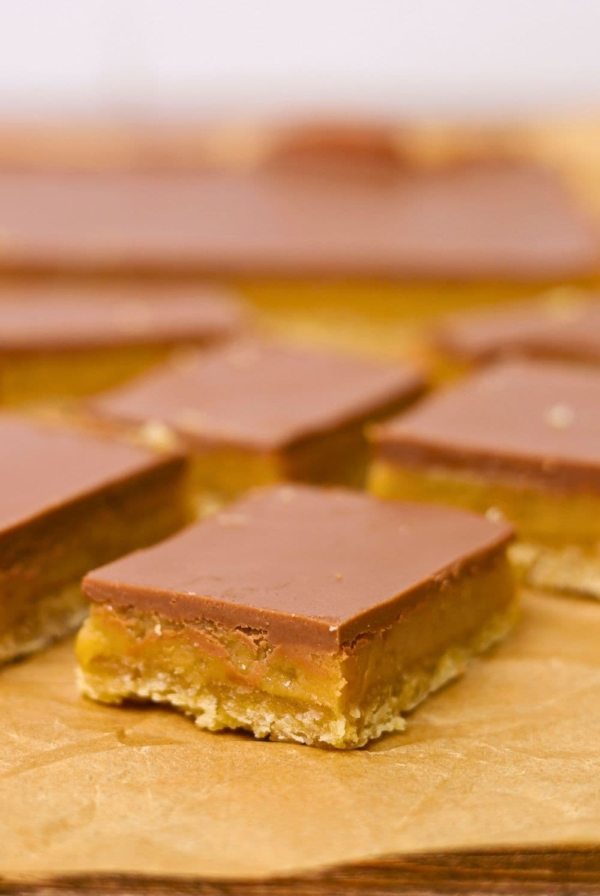 A close up image of a piece of sourdough caramel slice showing the gooey caramel inside.