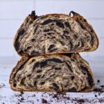 Two halves of a loaf of cookies and cream sourdough bread stacked on top of each other so you can see the crumb inside.