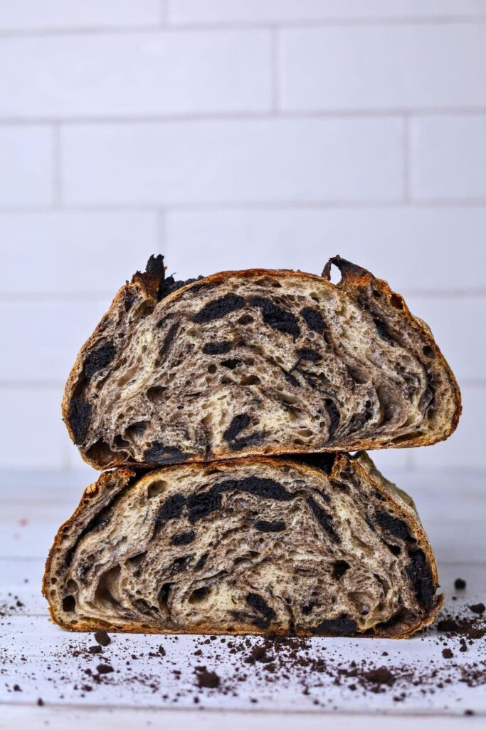 Two halves of sourdough cookies and cream sourdough bread stacked on top of each other so you can see the crumb inside.