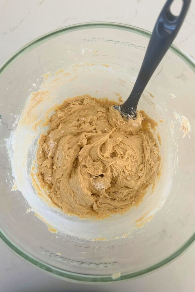 Wet and dry ingredients mixed together in a glass bowl.