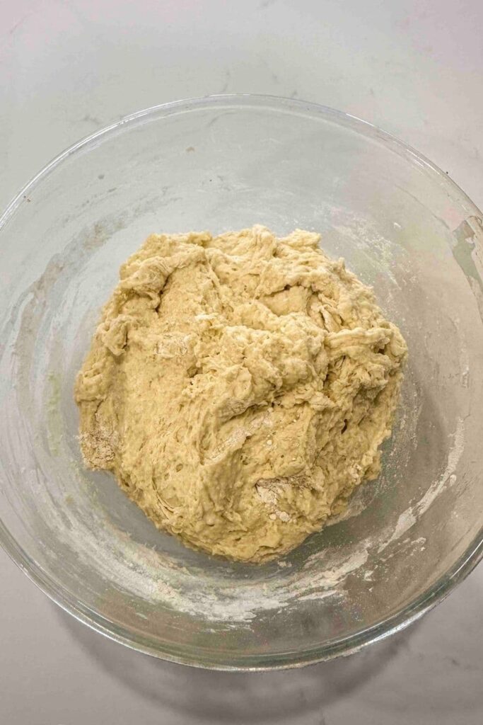 Sourdough English muffin loaf dough in glass bowl