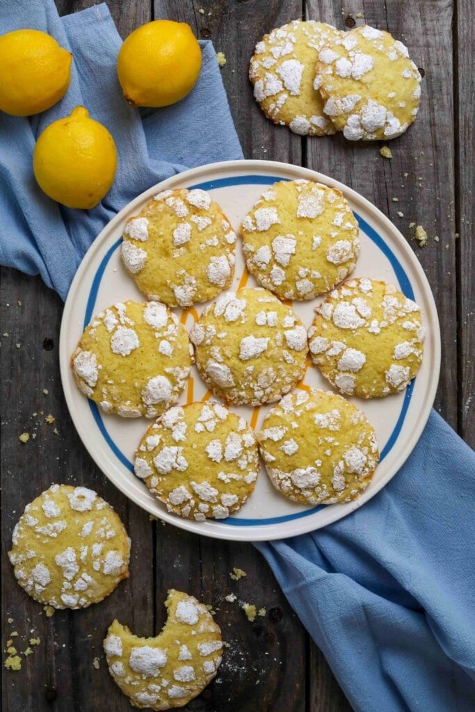 sourdough lemon crinkle cookies on a plate over a blue linen napkin.