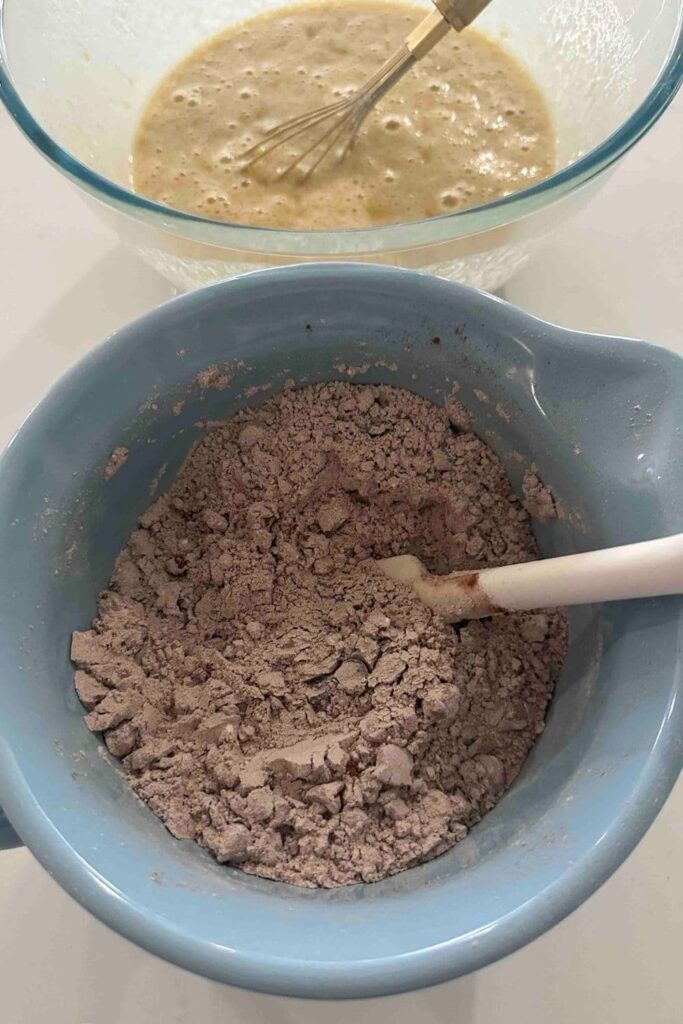 Mixing dry ingredients in a blue bowl to make double chocolate sourdough banana bread.