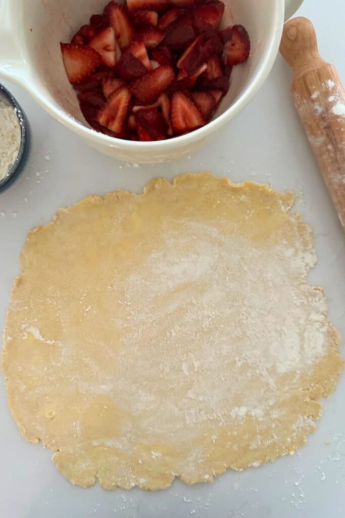 Sourdough discard strawberry galette crust rolled out into a rough circle. 