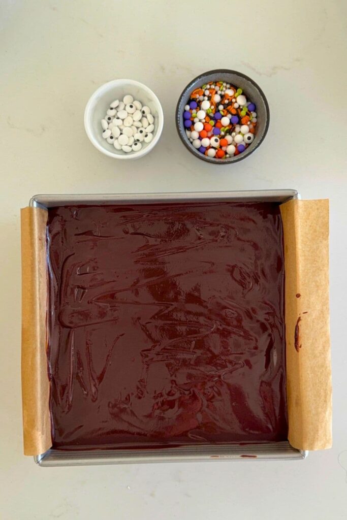 Sourdough Halloween frosted brownies in baking pan with ganache topping spread on top.