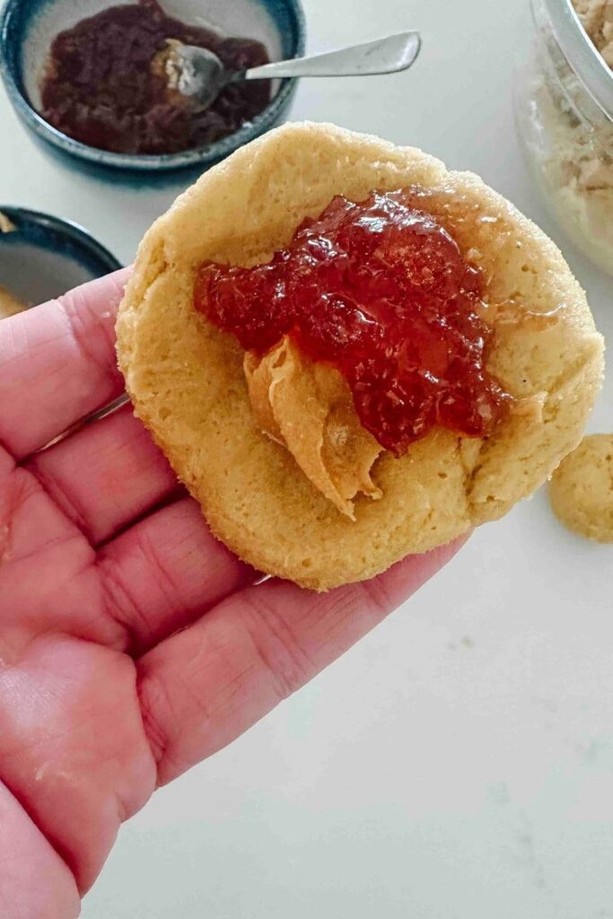 hand adding peanut butter and jelly to sourdough peanut butter and jelly cookie dough.