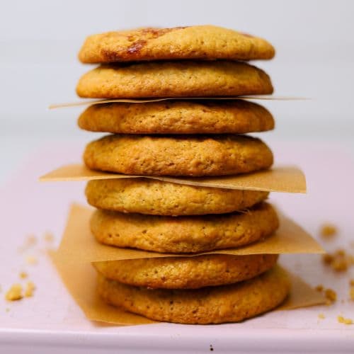 A stack of sourdough peanut butter and jelly cookies balanced on a pale pink baking tray.