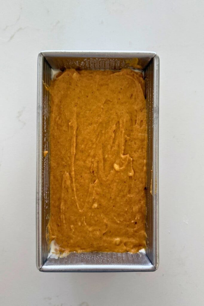 Sourdough pumpkin banana bread batter in a 1 pound loaf pan. It's ready to go into the oven.
