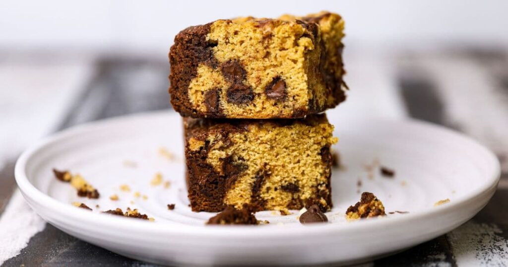 A stack of 2 sourdough brookies sitting on a white plate.