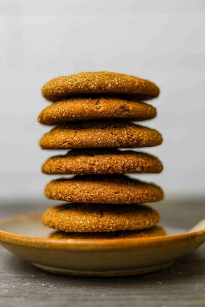 sourdough ginger molasses cookies stacked on small plate.