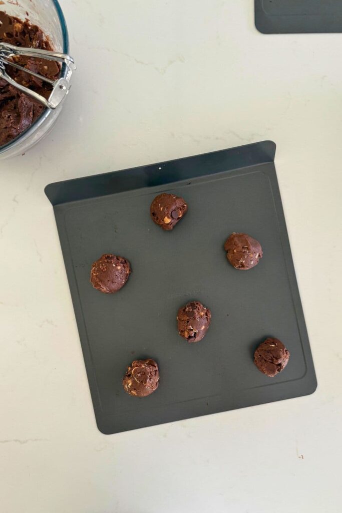 Cookie dough balls on baking sheet to make sourdough Halloween cookies.