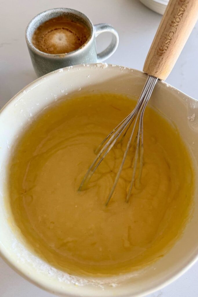 Sourdough Lemon loaf batter mixed in bowl with whisk.