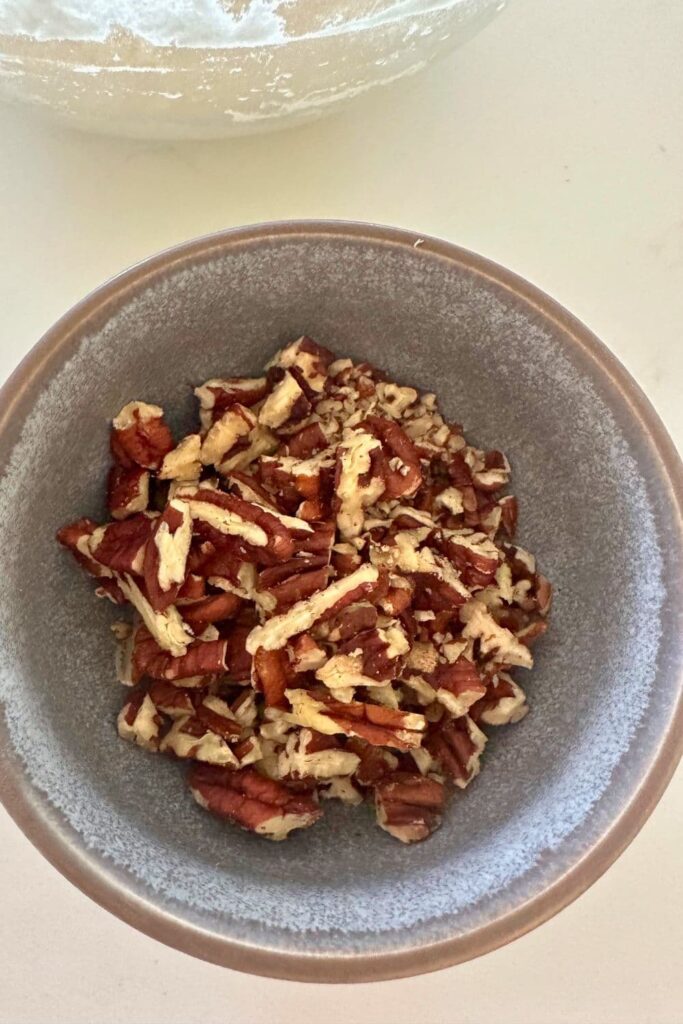 Chopped pecans in a bowl to make sourdough maple pecan loaf.