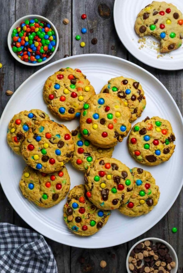 Plate with sourdough monster cookies sitting on wooden table.