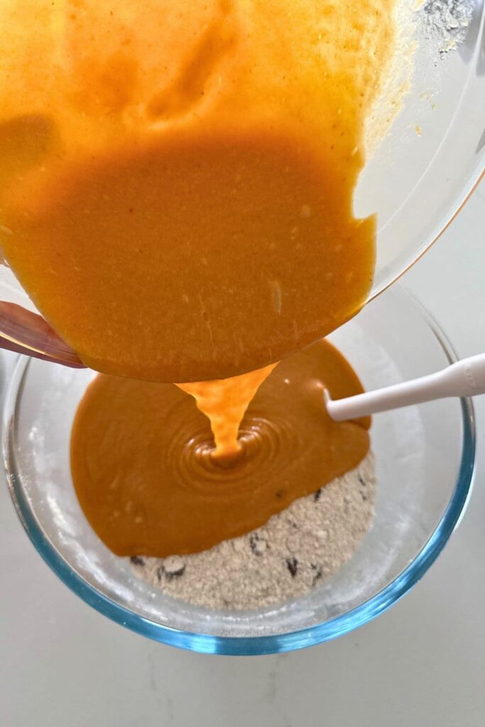 Mixing wet and dry ingredients together to make dough for sourdough pumpkin chocolate chip cookies.