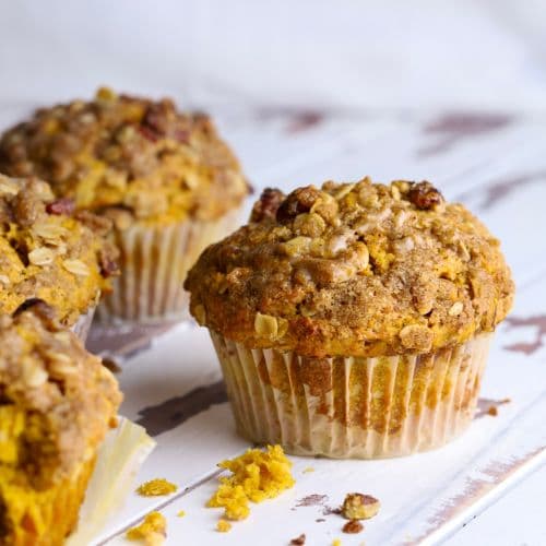 A close up image of sourdough pumpkin muffins topped with a brown sugar pecan streusel topping.