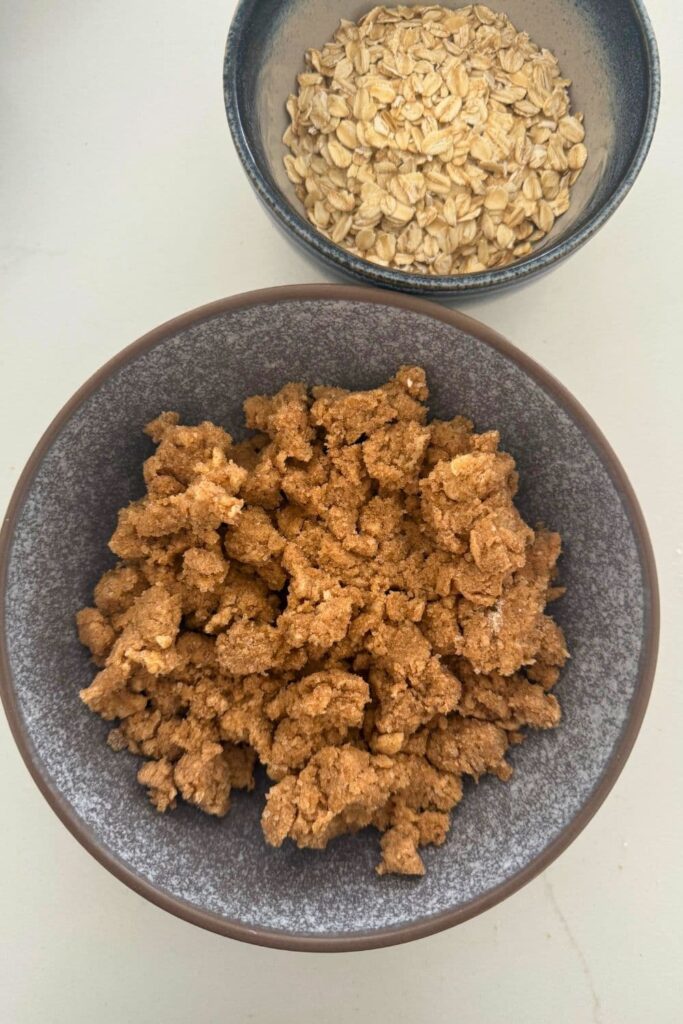 Showing the flour, sugars, cinnamon and butter mixed together in a bowl for the streusel topping for sourdough apple cinnamon rolls.