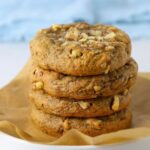Four sourdough date and walnut cookies stacked on a plate.