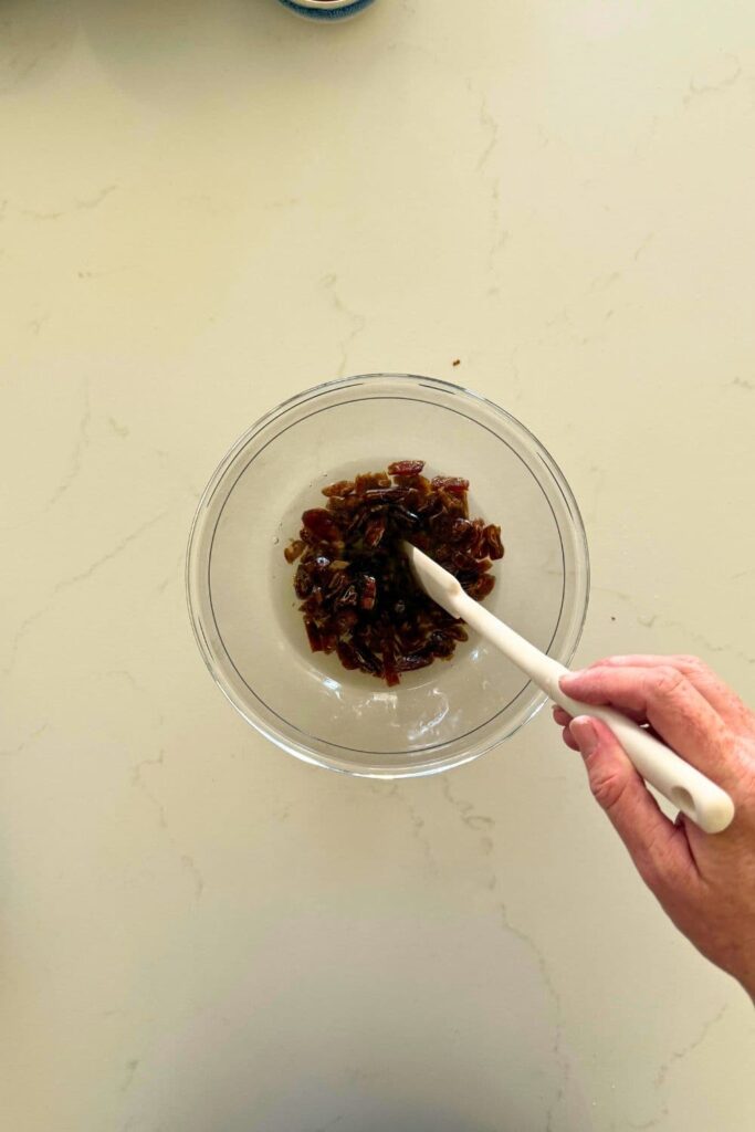 Soaking dates in water in a bowl to make sourdough date and walnut loaf cake.