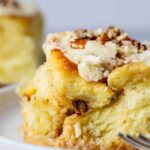 Sourdough maple pecan roll on a plate, zoomed in to show fluffy texture.