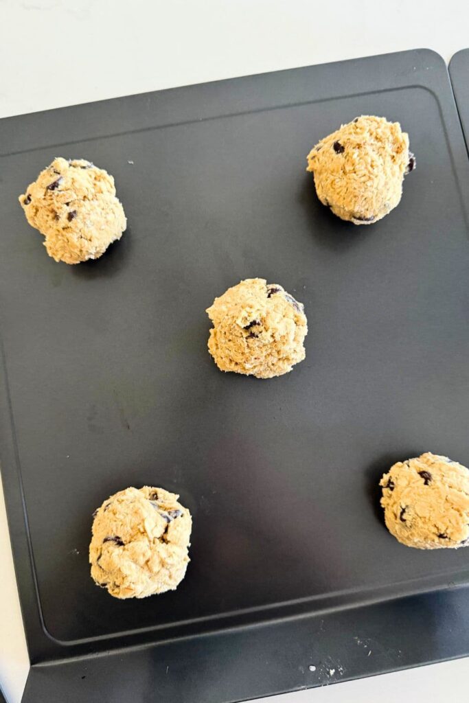 Sourdough Oatmeal Chocolate Chip Cookie dough balls on a cookie sheet ready to go in the oven.