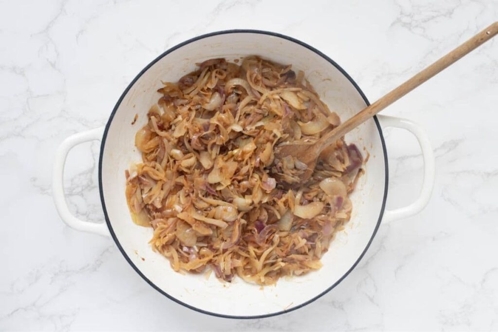 Onions starting to brown in Dutch oven to make caramelized onion relish.