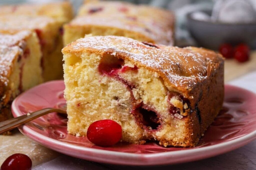 Close up of sourdough cranberry cake served on a plate with a fork.
