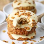 Three sourdough honey oat cookies stacked on a plate with a bite taken out of the top cookie.