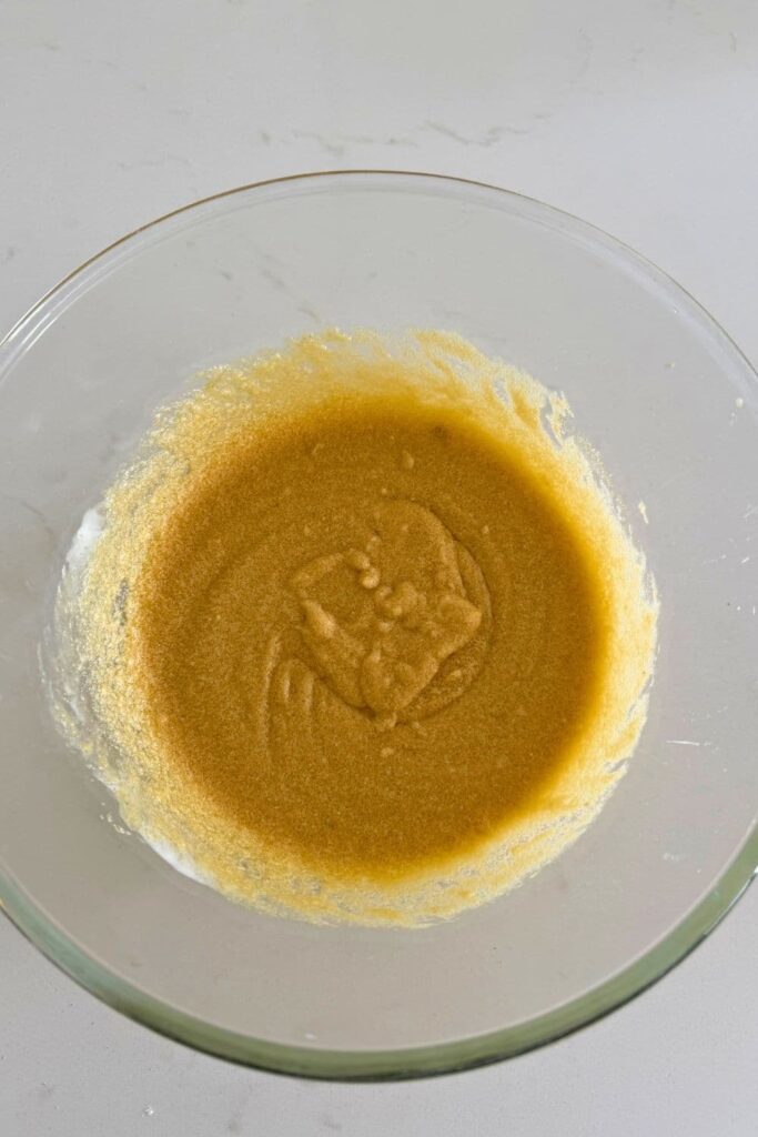 A bowl of mixed wet ingredients to make sourdough honey oat cookies.