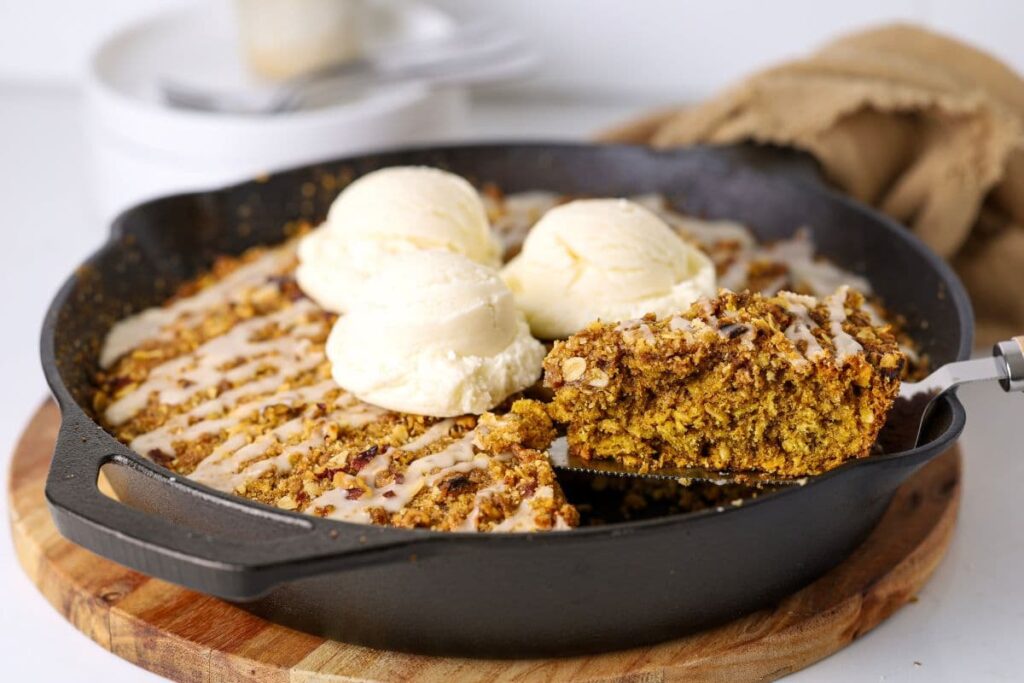 Sourdough oatmeal pumpkin cookie skillet being scooped out of skillet.