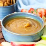Close up of a bowl of homemade caramel dip to show the texture on a serving tray.