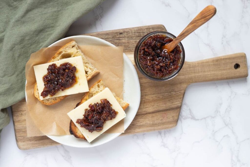 Bacon ham in a jar on a wooden board to be served over toasted sourdough and cheese.