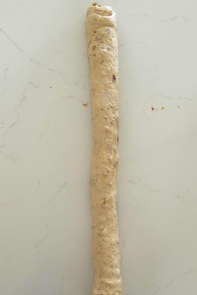 Dough for a sourdough maple pecan twist loaf rolled up.