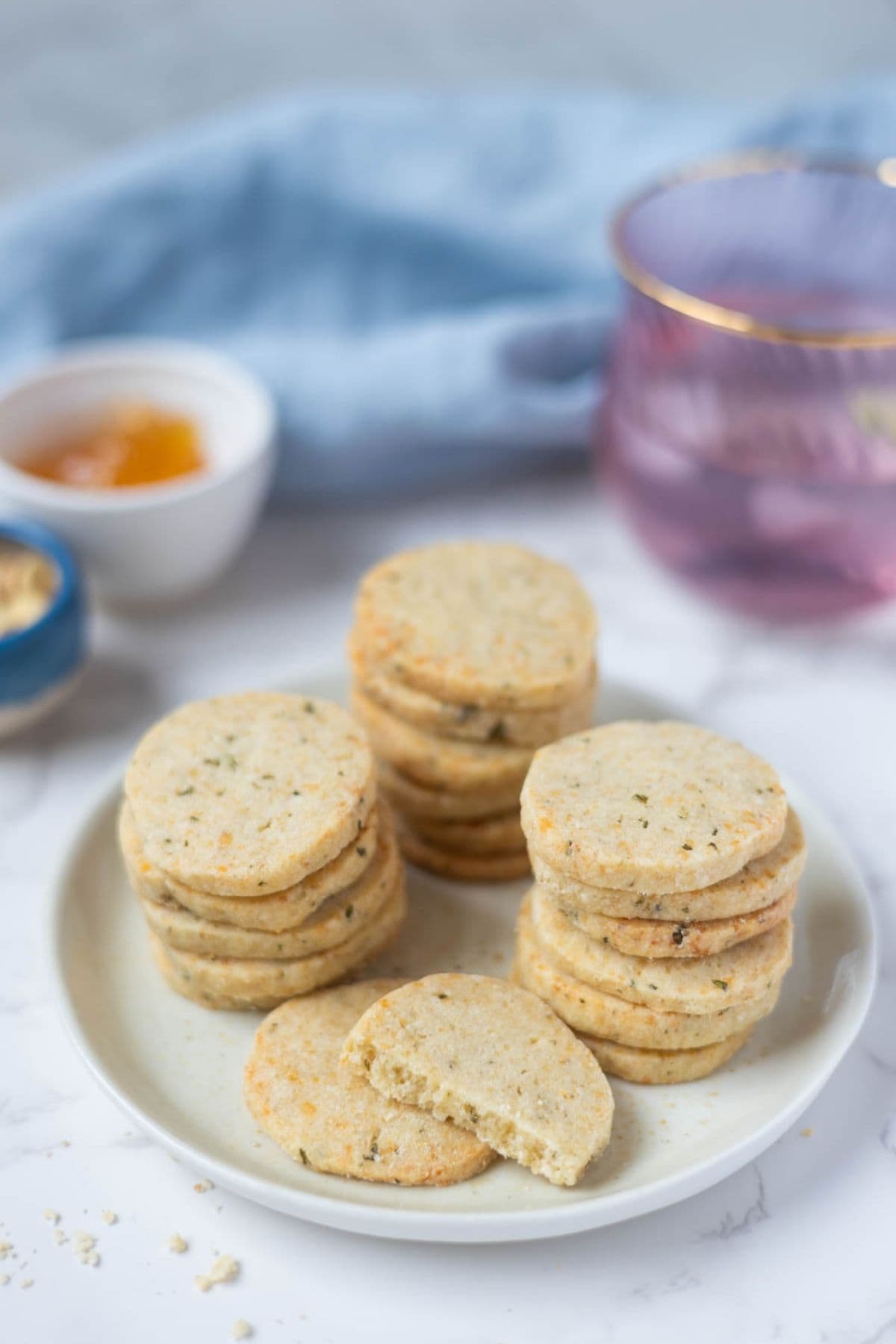 Stacked sourdough discard rosemary and parmesan shortbread on a serving plate.